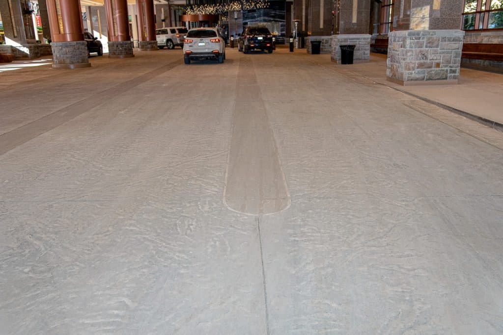 Close-up shot of decorative stamped concrete leading into a building's driveway.