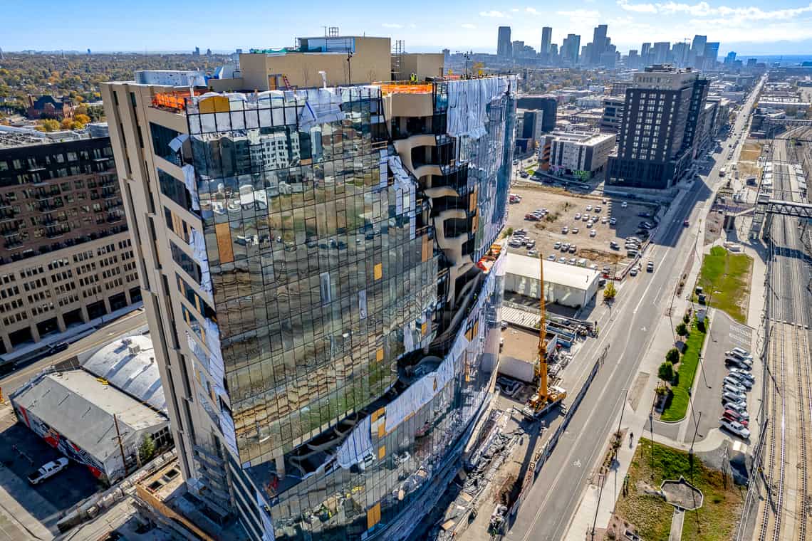 Side view of the One River North building under construction, with a crane still present on site.